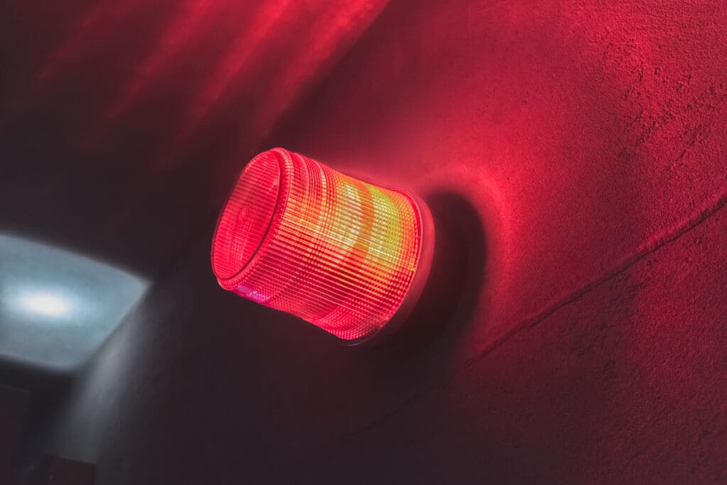 Wall mounted red warning light, spinning and blinking, air raid siren